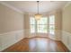 Elegant dining room with wainscoting, hardwood floors, and a chandelier with large windows at 3819 Meandering Sw Way, Lilburn, GA 30047