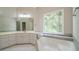 Luxurious main bathroom with a large soaking tub and window with a view to the trees at 3819 Meandering Sw Way, Lilburn, GA 30047