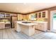 A spacious kitchen boasts an island with cooktop, white cabinets, and tile flooring at 5325 Pheasant Run, Stone Mountain, GA 30087