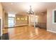 Spacious living area featuring hardwood floors, a decorative chandelier, columns, and access to the backyard at 5325 Pheasant Run, Stone Mountain, GA 30087