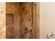 Shower with stone-look tilework, a built-in soap dish, and a stylish showerhead at 5325 Pheasant Run, Stone Mountain, GA 30087