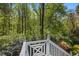 A serene view of the backyard and lush green landscape as seen from a beautiful white deck at 105 Grogans Lake Dr, Atlanta, GA 30350