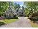 Charming home featuring a well-manicured lawn, mature trees, and a long driveway leading to the front entrance at 105 Grogans Lake Dr, Atlanta, GA 30350
