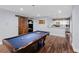 Stylish game room with pool table, sliding barn door, and snack area with white cabinets and stainless steel appliances at 105 Grogans Lake Dr, Atlanta, GA 30350