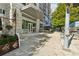 Elegant building entrance with glass doors, covered walkway, and professionally landscaped sidewalk at 1820 Peachtree Nw St # 804, Atlanta, GA 30309