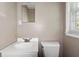 Simple bathroom with a white sink, toilet, and a window for natural light at 2262 Hurt Sw Rd, Marietta, GA 30008