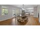 Open-concept dining area with hardwood floors, large windows, and a charming wooden table set at 2315 Fisher Dr, Loganville, GA 30052