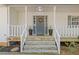 Inviting front porch with stone steps, potted plants, wreath, and white columns creating a warm entrance at 2315 Fisher Dr, Loganville, GA 30052
