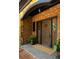 Close up of a custom wood double front door flanked by sidelights, brick facade, stone accents, and potted plants at 2015 N Decatur Ne Rd, Atlanta, GA 30307