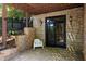 Covered stone patio with a sliding door, chair, and exterior lighting fixtures at 2015 N Decatur Ne Rd, Atlanta, GA 30307
