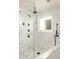 Modern bathroom shower featuring white marble tiling, rainfall shower head and a frameless glass door at 2015 N Decatur Ne Rd, Atlanta, GA 30307
