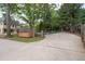 Expansive view of the backyard features a shed, a long driveway, and partial view of home's exterior at 5300 Coacoochee Ter, Johns Creek, GA 30022