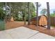 Large backyard featuring two storage sheds with ramp access, surrounded by mature trees and a concrete patio at 5300 Coacoochee Ter, Johns Creek, GA 30022