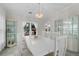 Formal dining room with a long white table, display cabinets, and a stylish chandelier at 5300 Coacoochee Ter, Johns Creek, GA 30022
