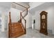 Elegant foyer with marble floors, wooden staircase, and a classic grandfather clock at 5300 Coacoochee Ter, Johns Creek, GA 30022