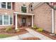Inviting front entrance with decorative columns, rocking chairs, and manicured landscaping at 5300 Coacoochee Ter, Johns Creek, GA 30022