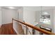Upstairs hallway features wood floors and view of the front yard at 5300 Coacoochee Ter, Johns Creek, GA 30022