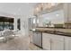 Eat-in kitchen with white cabinetry and stainless steel appliances, with access to a covered outdoor dining area at 5300 Coacoochee Ter, Johns Creek, GA 30022