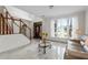 Elegant living area with staircase, dark wood front door, and natural light streaming through large windows at 5300 Coacoochee Ter, Johns Creek, GA 30022
