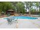 Inviting outdoor pool and gazebo surrounded by lush greenery and a decorative stone border at 5300 Coacoochee Ter, Johns Creek, GA 30022