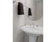Powder room featuring a pedestal sink and a round mirror at 5300 Coacoochee Ter, Johns Creek, GA 30022