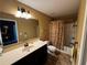 A full bathroom with a large mirror, a single sink vanity, a toilet, and a shower over bath with a curtain at 1598 Lenox Overlook Ne Rd, Atlanta, GA 30329