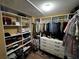 A large walk-in closet with storage shelves, storage drawers, hanging clothes, many pairs of shoes, and other storage items at 1598 Lenox Overlook Ne Rd, Atlanta, GA 30329