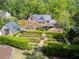 Aerial view of estate features a brick home, guest house, and manicured garden at 2648 Rivers Nw Rd, Atlanta, GA 30305