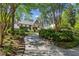 A winding driveway leads to a brick home with lush landscaping and mature trees at 2648 Rivers Nw Rd, Atlanta, GA 30305