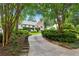 Charming two-story home with brick facade, ivy, and landscaped yard with mature trees lining the driveway at 2648 Rivers Nw Rd, Atlanta, GA 30305