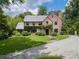Charming brick Tudor-style home features lush landscaping, mature trees, and a circular driveway at 2648 Rivers Nw Rd, Atlanta, GA 30305