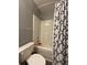 Bright bathroom with a toilet and a shower featuring a patterned blue and white shower curtain at 305 Pleasant Forest Dr, Temple, GA 30179