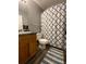 Bathroom with wood cabinets, stylish sink and a blue patterned shower curtain at 305 Pleasant Forest Dr, Temple, GA 30179