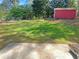 Expansive backyard with lush green lawn and privacy fence and red shed at 3510 Beaver Cove Rd, Cumming, GA 30041