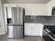 Modern kitchen featuring stainless steel appliances, white cabinetry, and gray subway tile backsplash at 1703 Feast Ct, Cumming, GA 30040