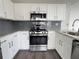 Updated kitchen showcasing stainless steel oven, microwave, and white cabinets at 1703 Feast Ct, Cumming, GA 30040