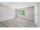 This bedroom features gray walls, gray vinyl floors, a large window, and a white door at 1703 Laurel Creek Cir, Lithonia, GA 30058