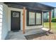 Inviting front porch features a dark-colored door and window with natural wood columns at 1703 Laurel Creek Cir, Lithonia, GA 30058