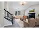 Bright living room featuring neutral-toned walls, vinyl floors, a black fireplace, and a staircase at 1703 Laurel Creek Cir, Lithonia, GA 30058