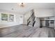 Bright living room with neutral walls, vinyl floors, black staircase, and ample natural light at 1703 Laurel Creek Cir, Lithonia, GA 30058