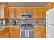 Galley kitchen features stainless steel appliances, light countertops, and wood cabinets at 200 Arrowhead Ln, Canton, GA 30114