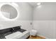 Modern bathroom with round mirror and black marble sink adjacent to toilet at 221 Silver Springs Sw Cir, Atlanta, GA 30310