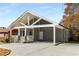 Gray home features a covered porch, carport, and modern front door, with a concrete driveway offering ample parking at 221 Silver Springs Sw Cir, Atlanta, GA 30310