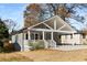 Charming home with a gray exterior, a covered porch and a spacious carport, all sitting on a well-maintained lot at 221 Silver Springs Sw Cir, Atlanta, GA 30310