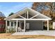 Charming home boasts a gray exterior, covered porch, carport, and modern front door, offering curb appeal at 221 Silver Springs Sw Cir, Atlanta, GA 30310