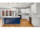 Well-lit kitchen boasts a blue island, stainless steel appliances, and white cabinetry at 221 Silver Springs Sw Cir, Atlanta, GA 30310