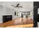 Bright, open living space with fireplace, modern ceiling fan, hardwood floors, and seamless flow to the kitchen at 221 Silver Springs Sw Cir, Atlanta, GA 30310