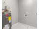 Utility room featuring water heater and white tiled floors and walls at 221 Silver Springs Sw Cir, Atlanta, GA 30310