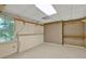 Unfinished basement area with shelving, neutral carpet and walls, and a large window at 3200 Country Club Nw Ct, Kennesaw, GA 30144