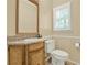 Cozy half bathroom featuring vanity with granite top, wood cabinets, and a window with blinds at 3200 Country Club Nw Ct, Kennesaw, GA 30144